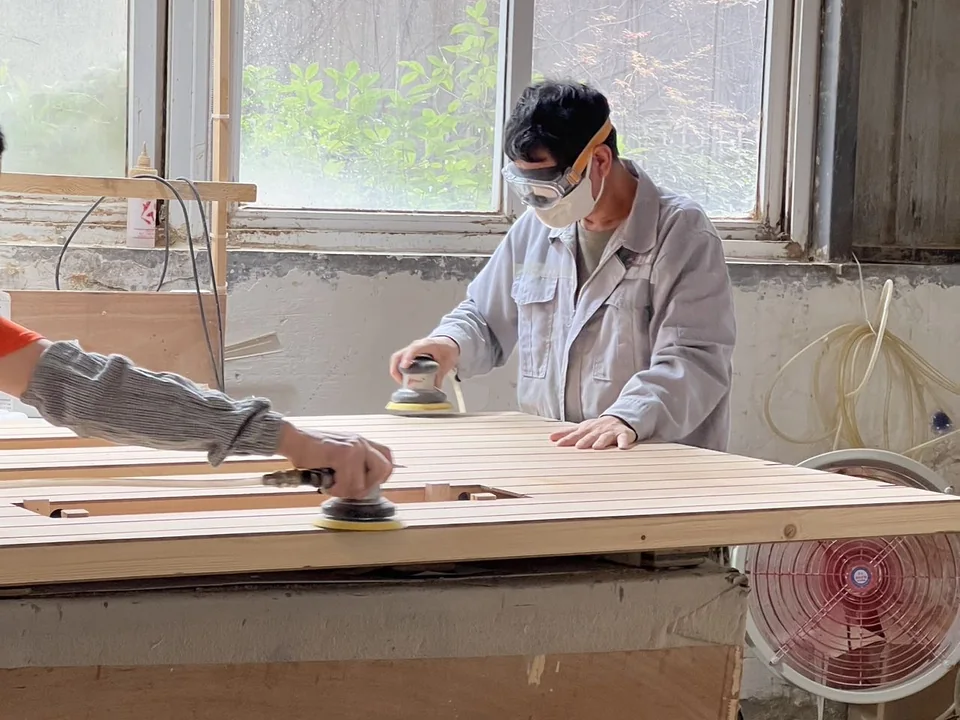 Worker sanding sauna wood components