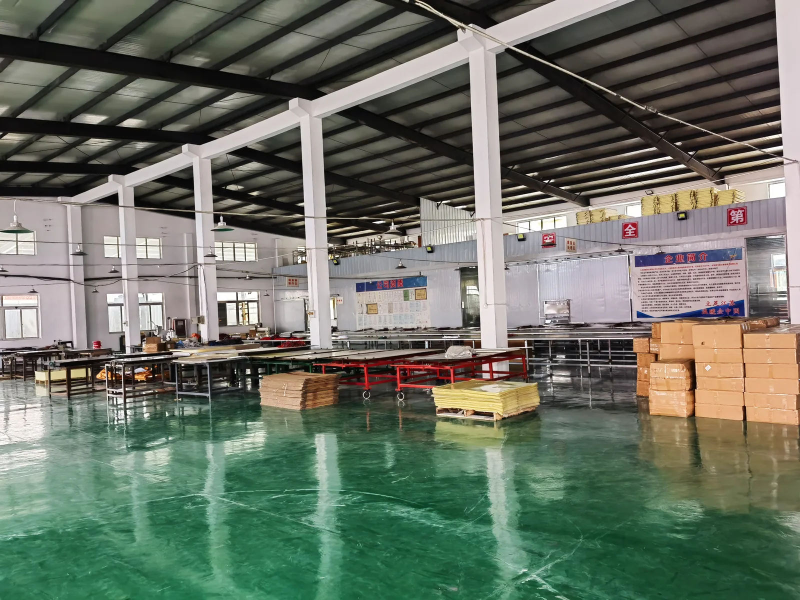 Factory floor with worktables, prepared materials and production equipment